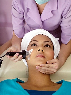 A close-up image of a person undergoing microdermabrasion treatment, with a handheld device gently exfoliating the skin.